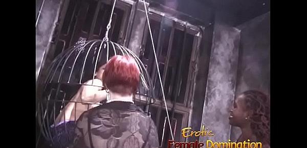  Two kinky mistresses take it out on a caged brunette slave